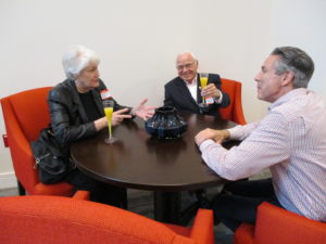 Residents seated at a table talking with a staff member in a common area.
