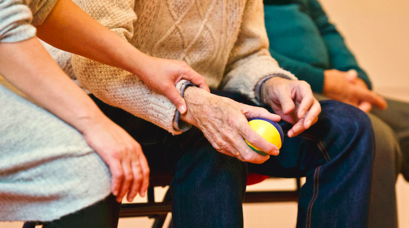 close up photo of a senior resident holding a stress ball
