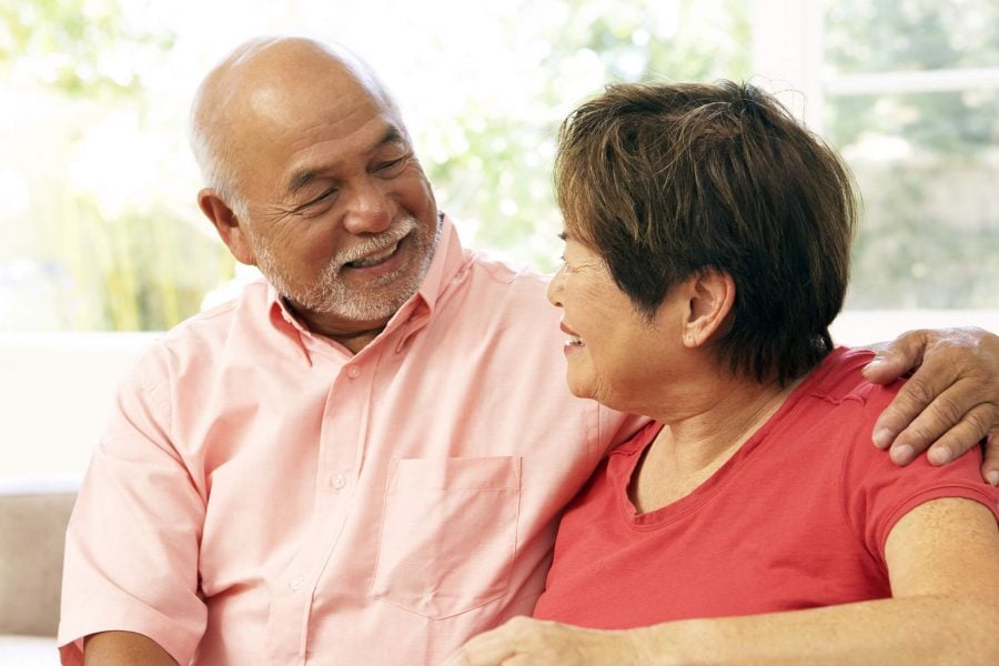 two senior residents embracing in their living room