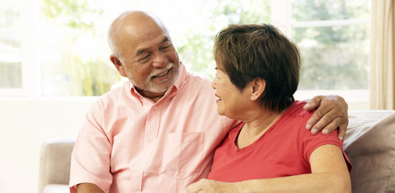 two senior residents embracing in their living room