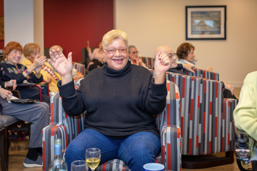 senior woman celebrating in the communal room at The Carrington