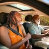 A happy senior couple laughing and smiling as they sit in the front seats of a SUV